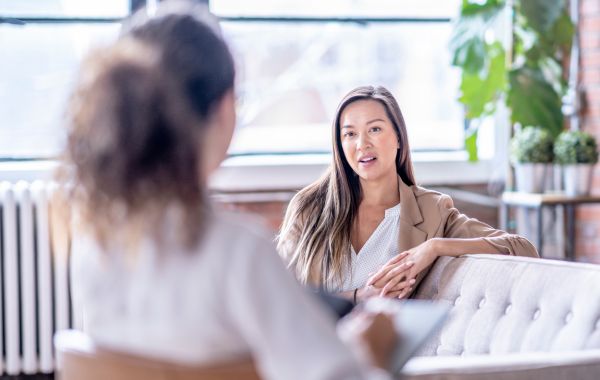 Two women speaking at a counselor's office.